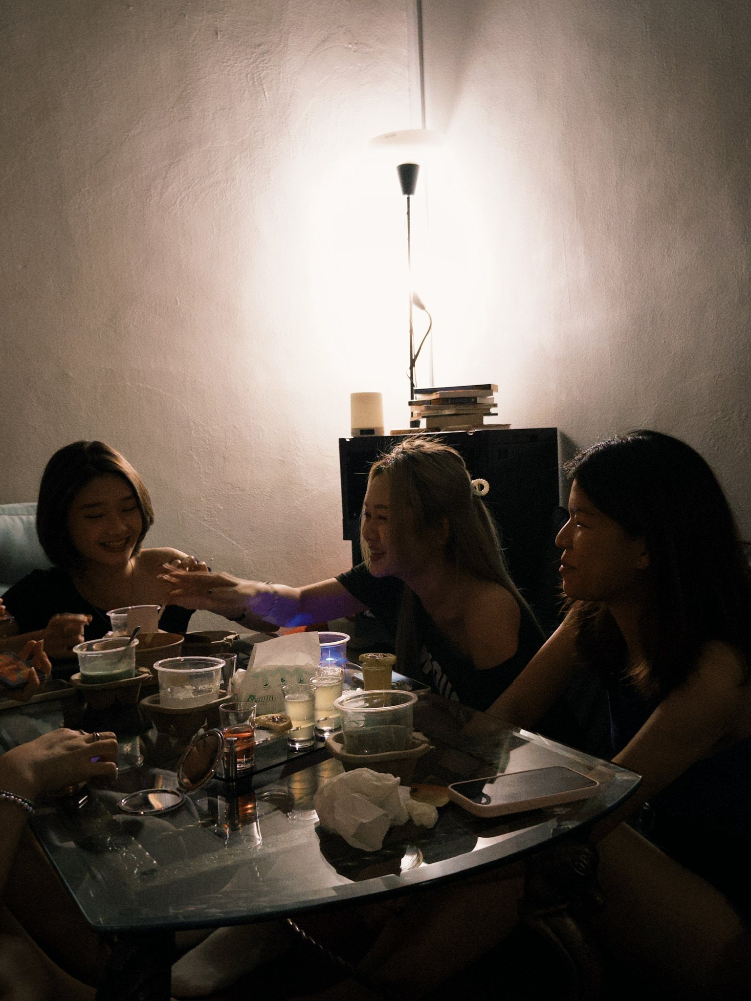 Friends around a warmly lit table inside So Bar